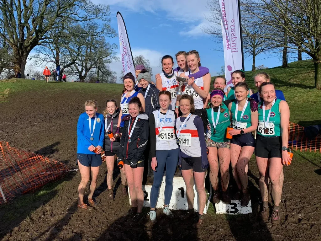 Fife AC women on the podium with a trophy after a cross-country race
